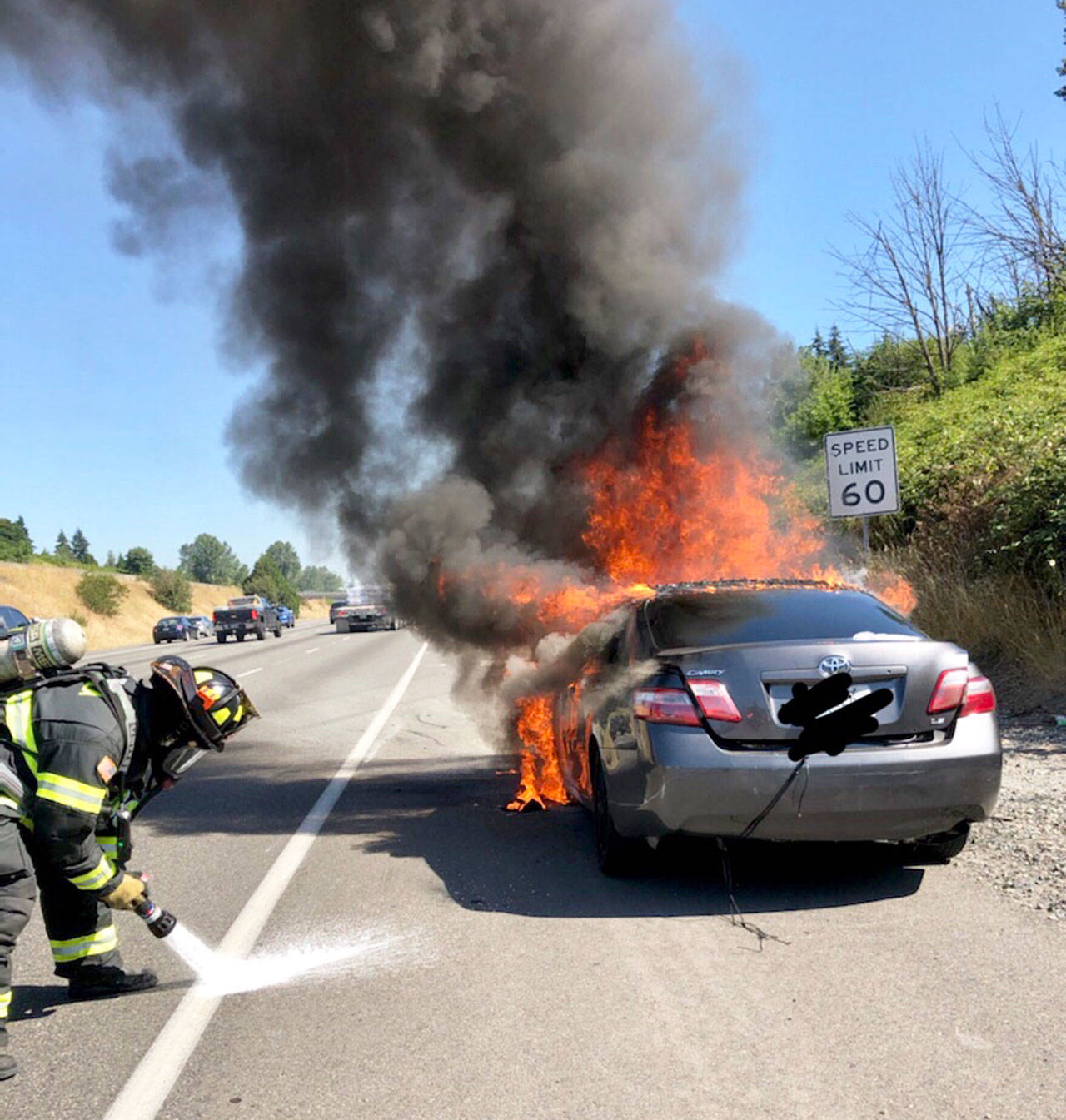 Firefighters attack a car fire Monday morning, July 27, along Interstate 5 northbound near the South 188th Street exit in SeaTac. COURTESY PHOTO, Tukwila Fire