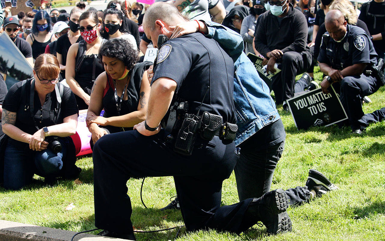 Kent Police Chief Rafael Padilla invites the crowd to take a knee with him on the lawn of the Maleng Regional Justice Center on June 11 prior to a protest march along downtown streets after the death of George Floyd, who was killed by a Minneapolis police officer. STEVE HUNTER, Kent Reporter