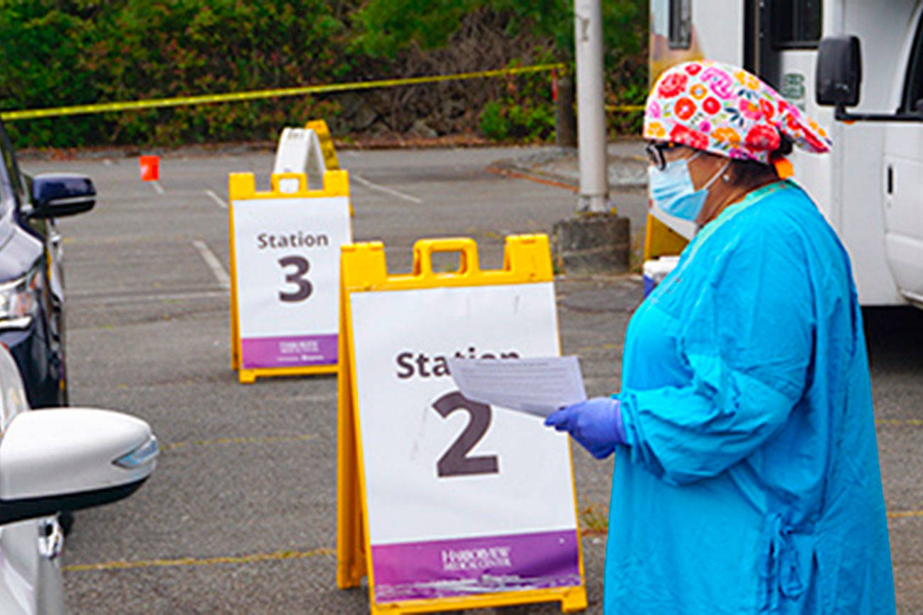 A health care worker administers a COVID-19 test in the Highline College East parking lot in Des Moines, where testing takes place 7 a.m. to 1 p.m. every Wednesday. Testing also is available 7 a.m. to 1 p.m. every Thursday at the accesso ShoWare Center parking lot in Kent. COURTESY PHOTO
