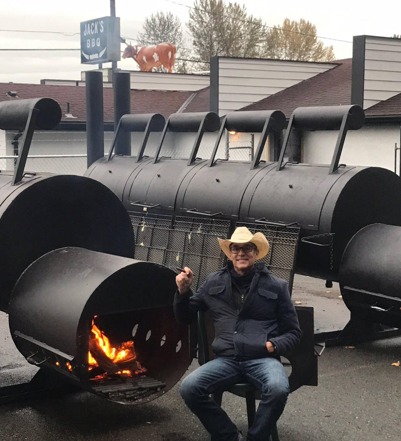 Jack Timmons pauses for a smoke next to his two giant smokers at Jack’s BBQ, which he opened Oct. 31 on West Valley Highway in Algona.