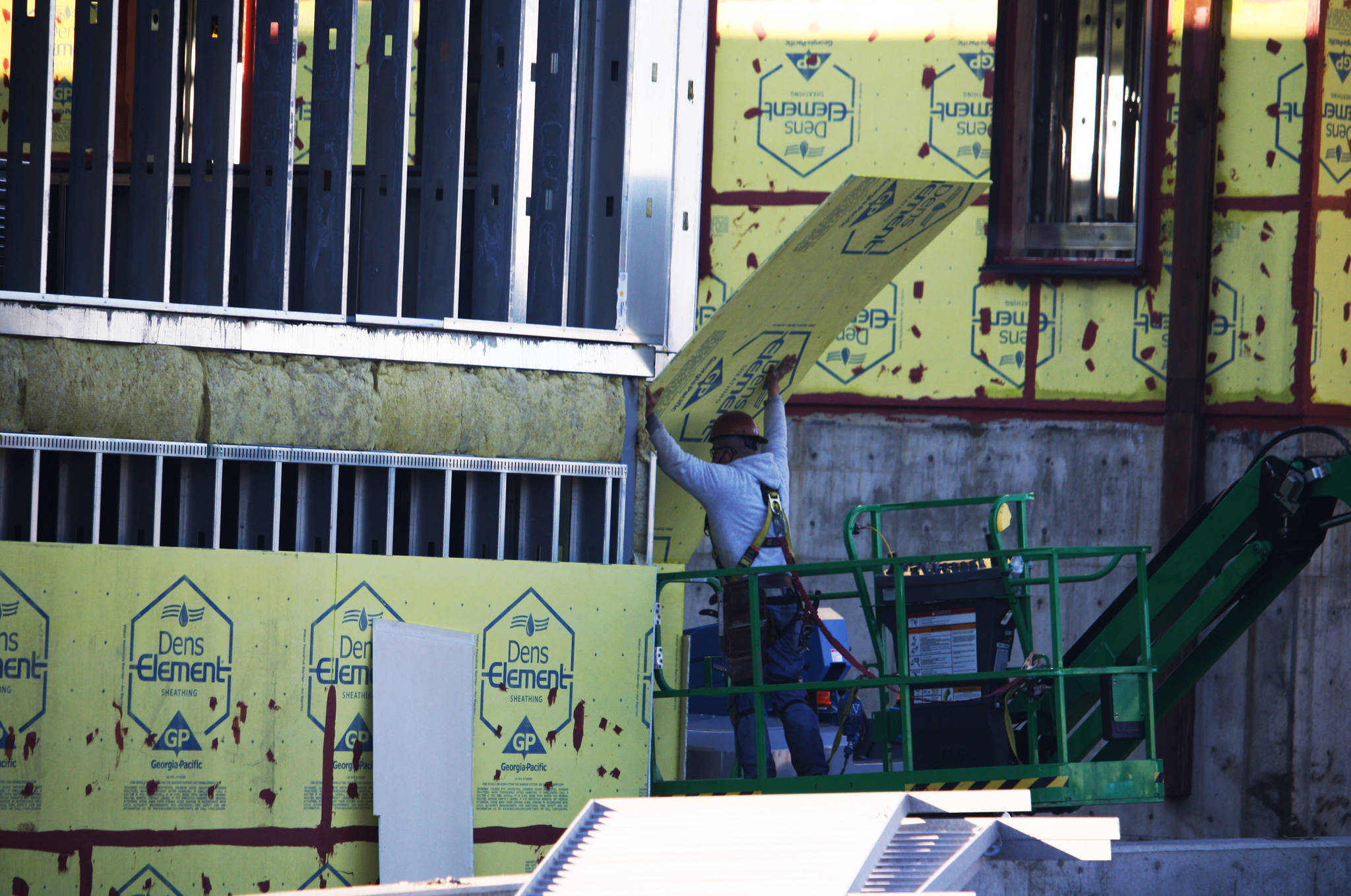 A construction crew member puts up sheathing Dec. 28 at what is proposed to be called the Kent Laboratory Academy. STEVE HUNTER, Kent Reporter