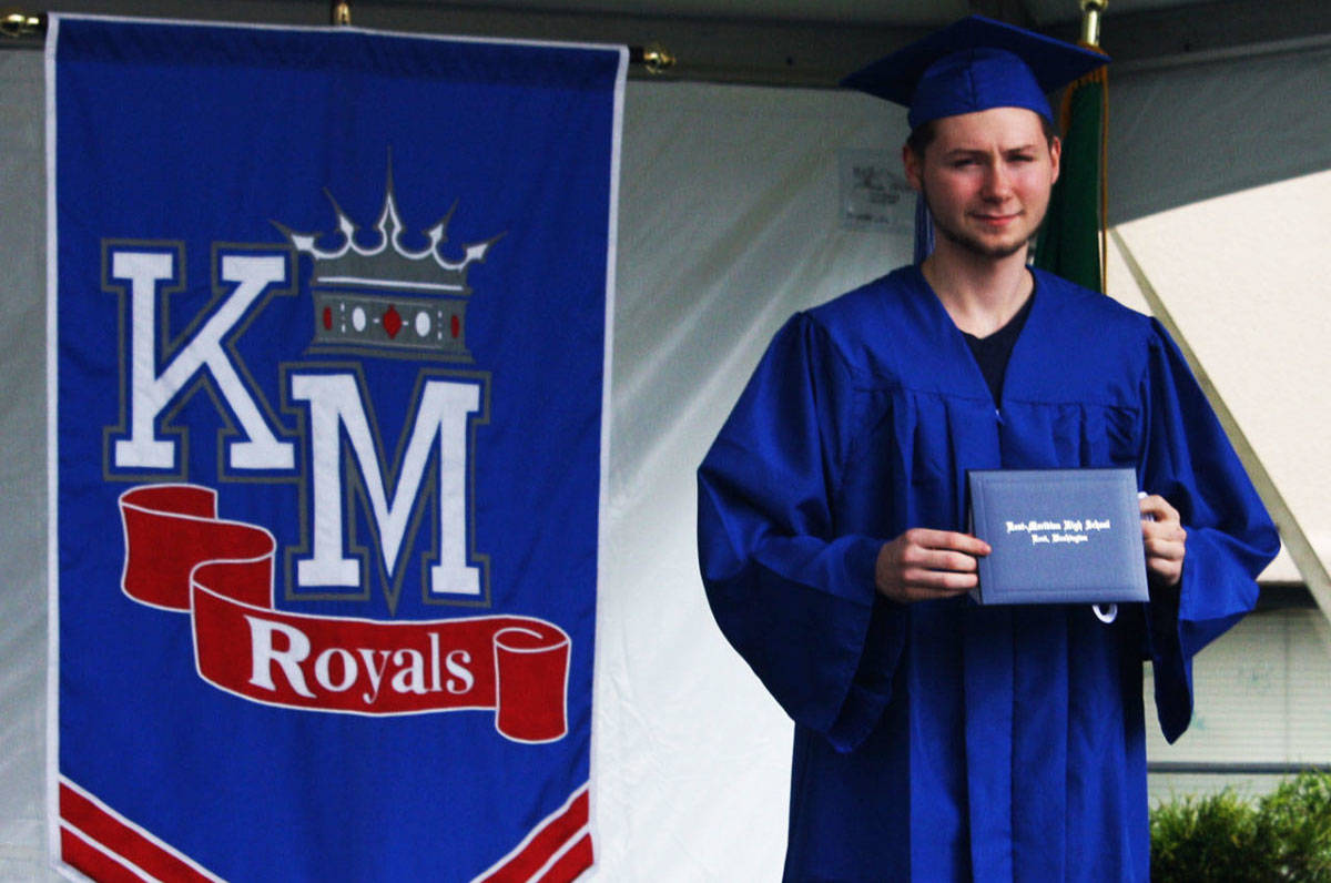 A Kent-Meridian High graduate receives his diploma cover during the 2020 graduation ceremony at the school. FILE PHOTO, Kent Reporter