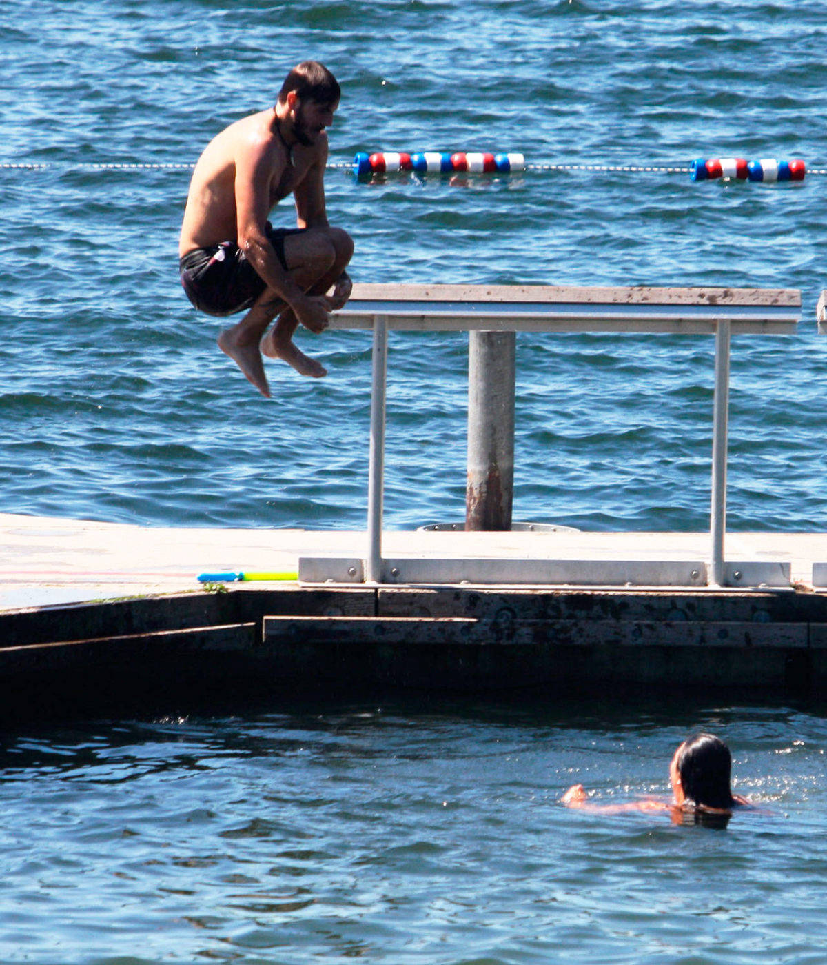 A swimmer jumps into Lake Meridian in Kent last summer. FILE PHOTO, Kent Reporter