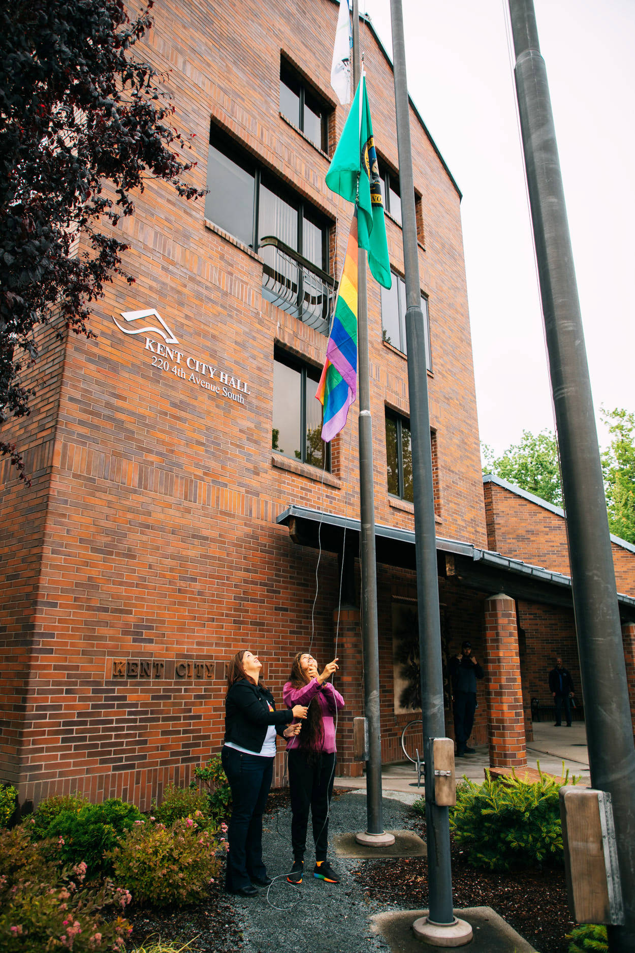 Kent City Councilmembers Marli Larimer, left, and Satwinder Kaur raise the Pride flag June 14 at City Hall. COURTESY PHOTO, City of Kent
