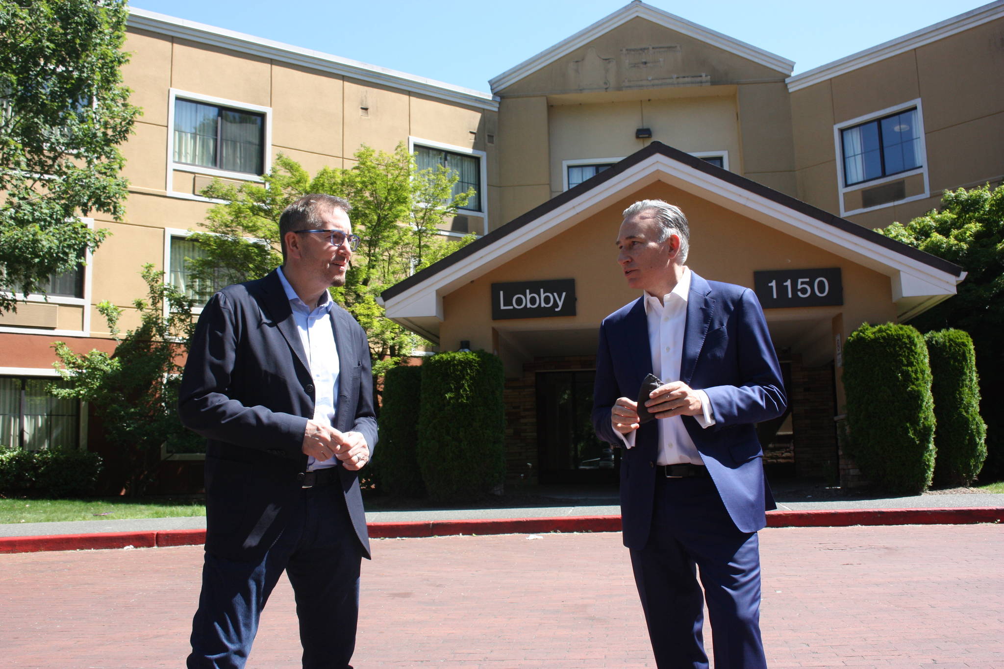Renton Mayor Armondo Pavone (left) and King County Executive Dow Constantine (right) discuss in front of the newly purchased shelter (Photo by Cameron Sheppard/Sound Publishing)