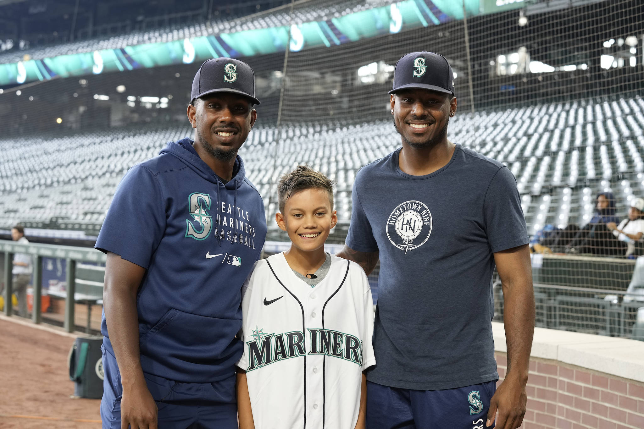 Hometown Nine fellow Imani Brown (center) poses for a photo with Mariners pitcher Justin Dunn (Left) and Mariners outfielder Kyle Lewis during an event for the Hometown Nine class of 2026 at T-Mobile Park. Photo by Ben VanHouten/ Seattle Mariners.