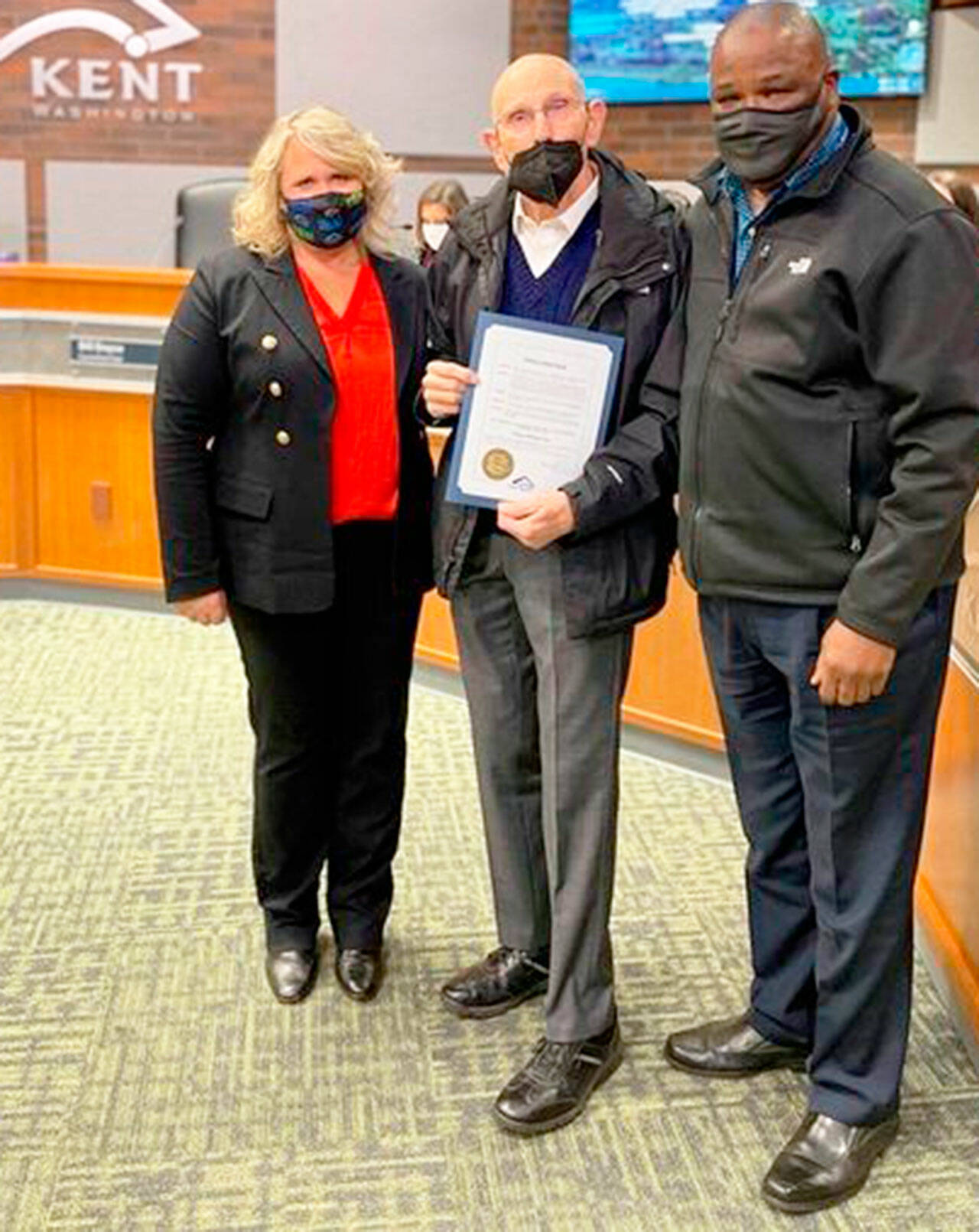 Kent Mayor Dana Ralph, left, and City Councilmember Bill Boyce, right, on Nov. 2 at City Hall present the Marge Williams Day proclamation to Harry Williams, the husband of the late Marge Williams. COURTESY PHOTO, City of Kent