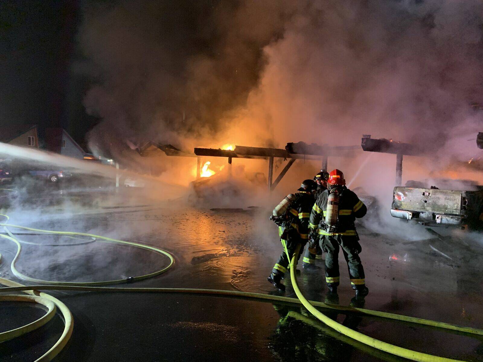Firefighters spray water at a carport engulfed in flames at the Riverfront Apartment complex on 8th Street Southeast in Auburn. The apartment complex was engulfed in a three-alarm fire Sunday night. Photo courtesy of Valley Regional Fire Authority.
