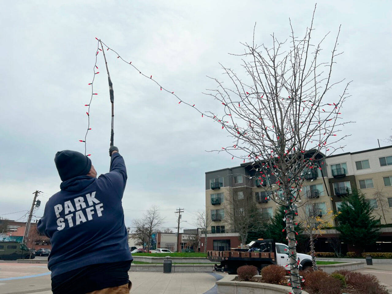 A city of Kent employee strings lights at Town Square Plaza, part of the Winterfest celebration. A tree lighting and parade are set for Saturday, Dec. 4. COURTESY PHOTO, City of Kent