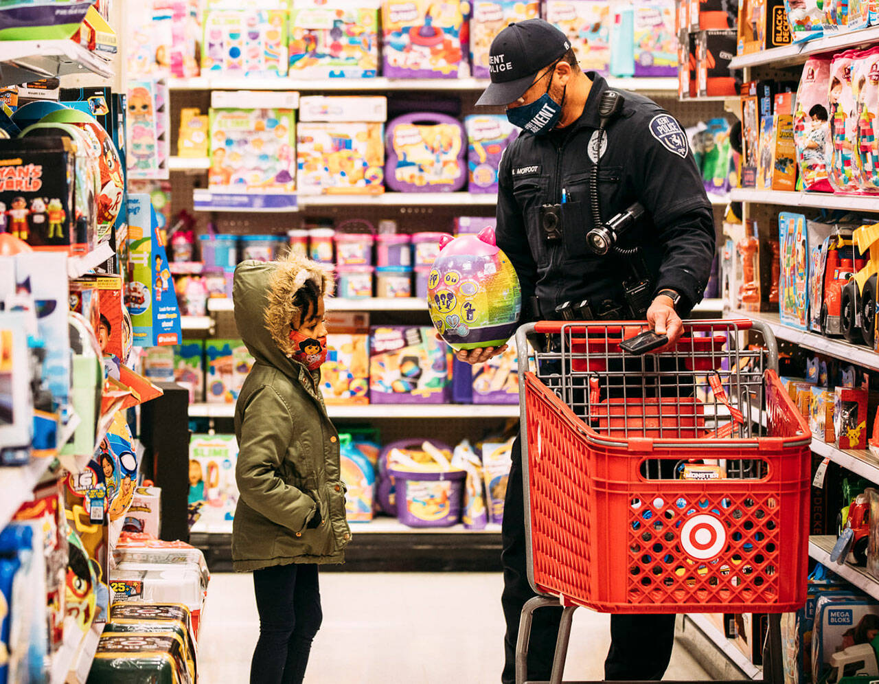 A Kent Police officer helps a child select gifts during the eighth annual Shop with a Cop Dec. 4 at Target. COURTESY PHOTO, Kent Police Department