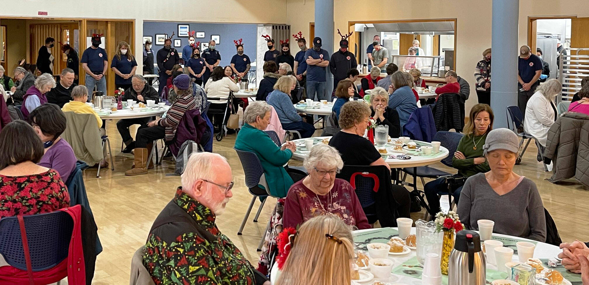 Attendees bow their heads in prayer prior to a Dec. 10 holiday luncheon at the Kent Senior Center presented by Puget Sound Fire. COURTESY PHOTO, Puget Sound Fire