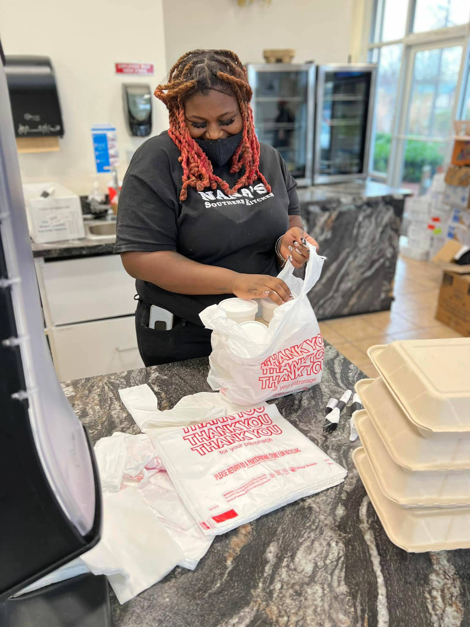 A Nana’s Southern Kitchen employee bags up dinners Christmas Day for a free meal to people in need. COURTESY PHOTO, Nana’s Southern Kitchen