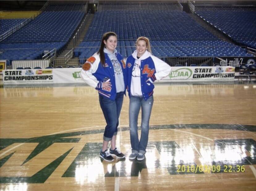Cait Carr, left, and Aly (Carr) Lacey pose for a photo in their varsity jackets. The sisters played together at Auburn Mountainview High School but now coach girls basketball at Auburn Mountainview and Kentlake High School, respectively. (Photo courtesy of Marla Carr)