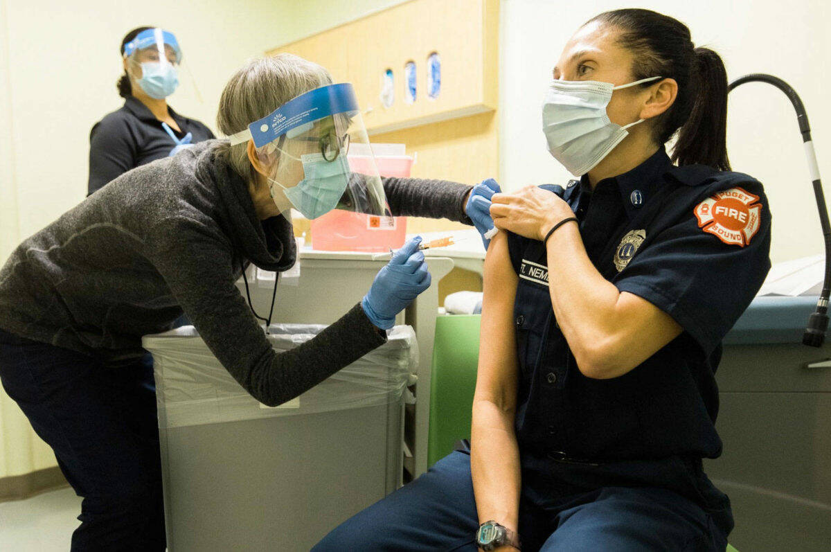 Public Health – Seattle & King County staff administer a COVID-19 vaccine to a local emergency responder. COURTESY FILE PHOTO, Public Health-Seattle & King County