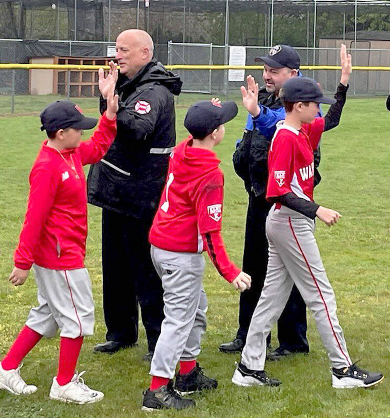 Puget Sound Fire Chief Matt Morris, left, and Kent Police Chief Rafael Padilla welcome players during Kent Little League Opening Day Saturday, April 30 at Ryan Brunner Park. COURTESY PHOTO, Puget Sound Fire