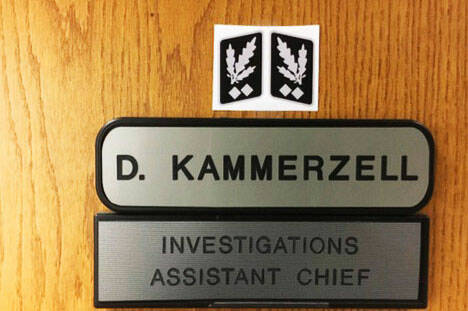 A screenshot from an investigator’s report about the Nazi symbol Kent Police Assistant Chief Derek Kammerzell placed above his nameplate on his office door.