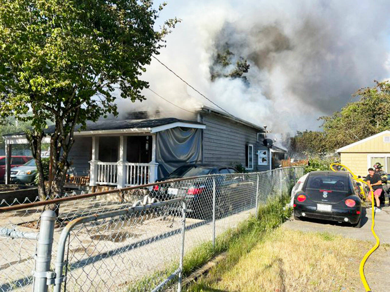 Firefighters extinguish a downtown Kent house fire Monday evening, June 27 in the 700 block of Railroad Avenue South. COURTESY PHOTO, Puget Sound Fire