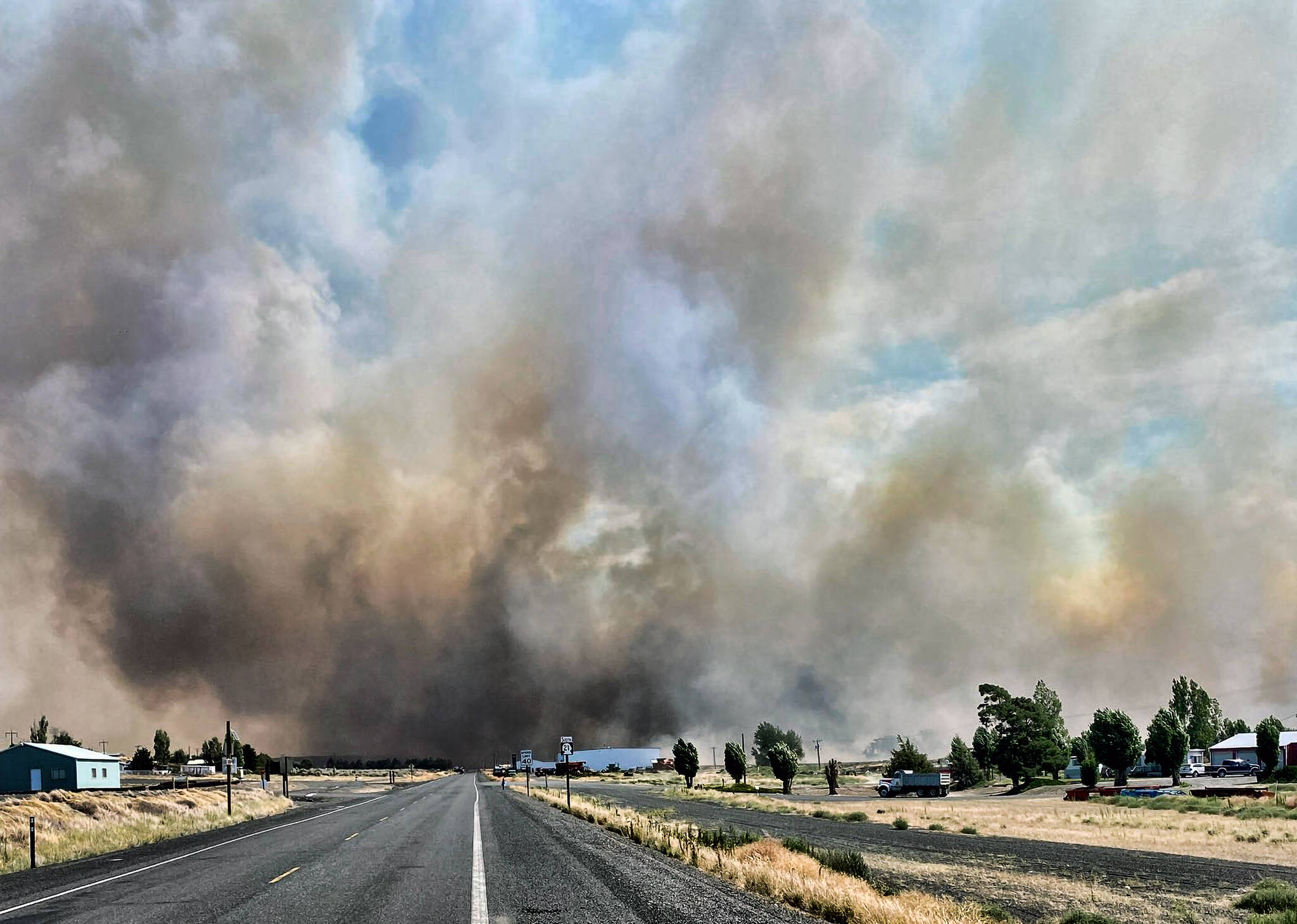 This photo provided by the Washington State Department of Transportation shows smoke from a wildfire burning south of Lind, Wash., on Thursday, Aug. 4, 2022. Sheriffs officials are telling residents in the Eastern Washington town to evacuate because of a growing wildfire south of town that was burning homes. (Courtesy photo)