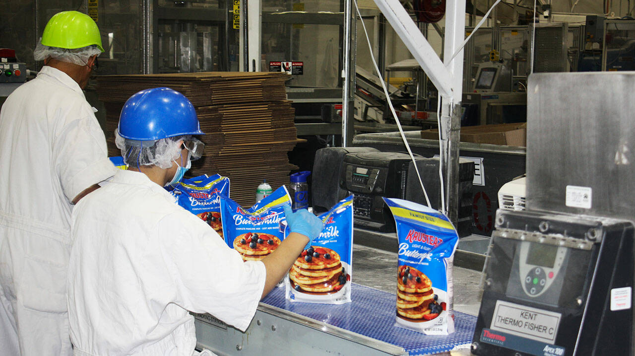 A worker checks the seals of a pancake mix along the production line at The Krusteaz Company plant in Kent. STEVE HUNTER, Kent Reporter