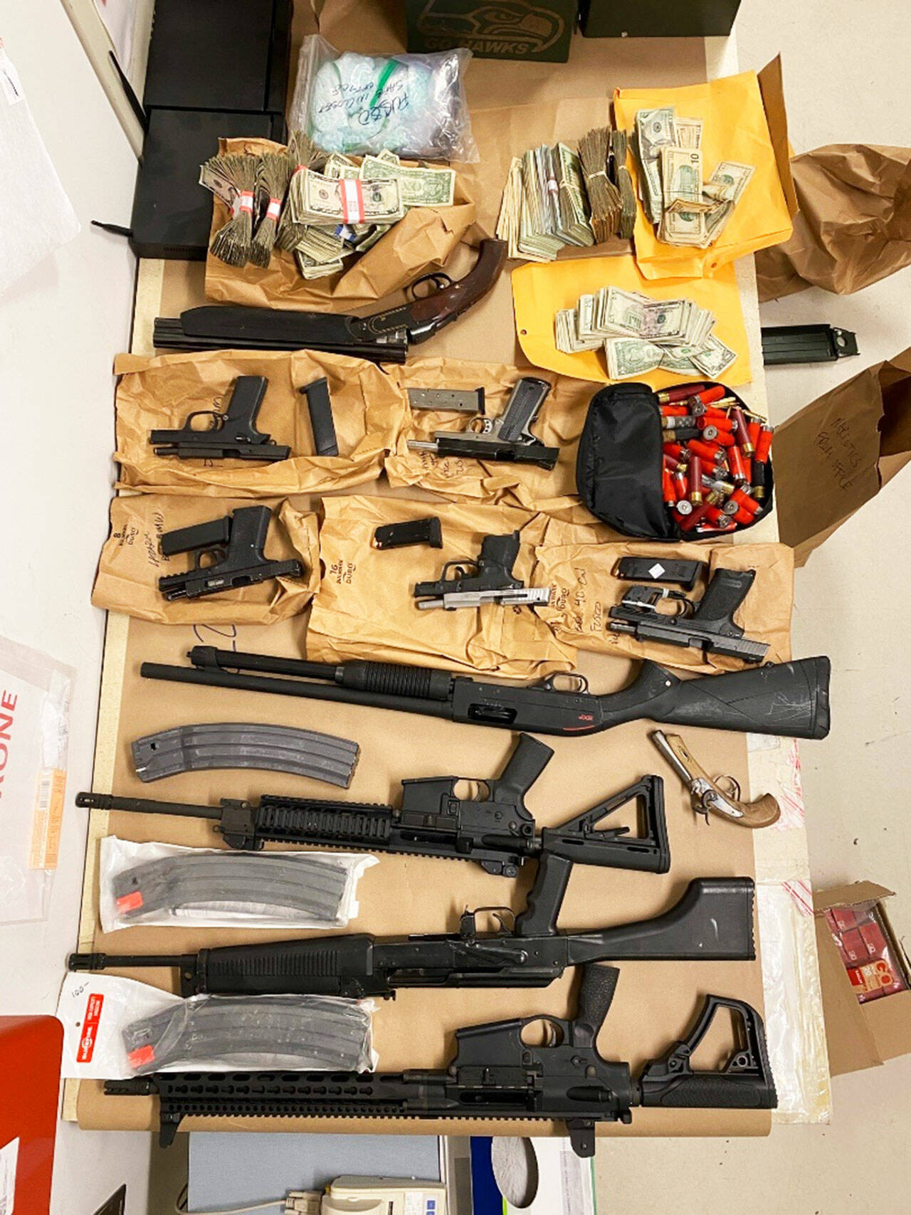 Guns and cash seized by federal law enforcement officers as part of a drug trafficking ring bust in Washington and California that resulted in 17 indictments on drug charges. COURTESY PHOTO, FBI