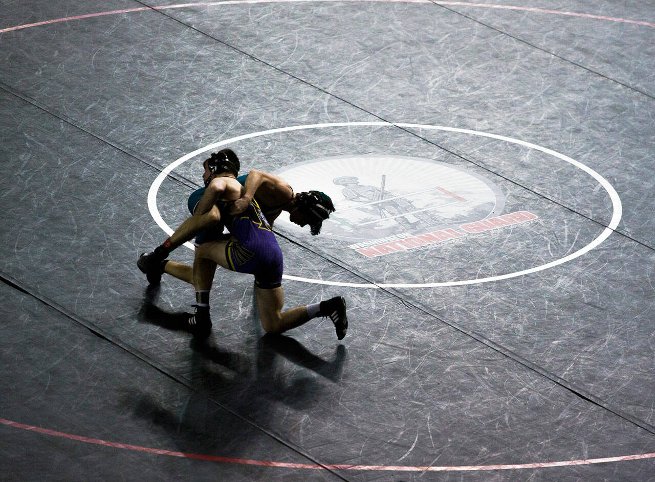 Wrestlers are silhouetted against a black wrestling mat during the Mat Classic XXXIII on Saturday, Feb. 19, 2022 in Tacoma, Washington. (Olivia Vanni / Sound Publishing)