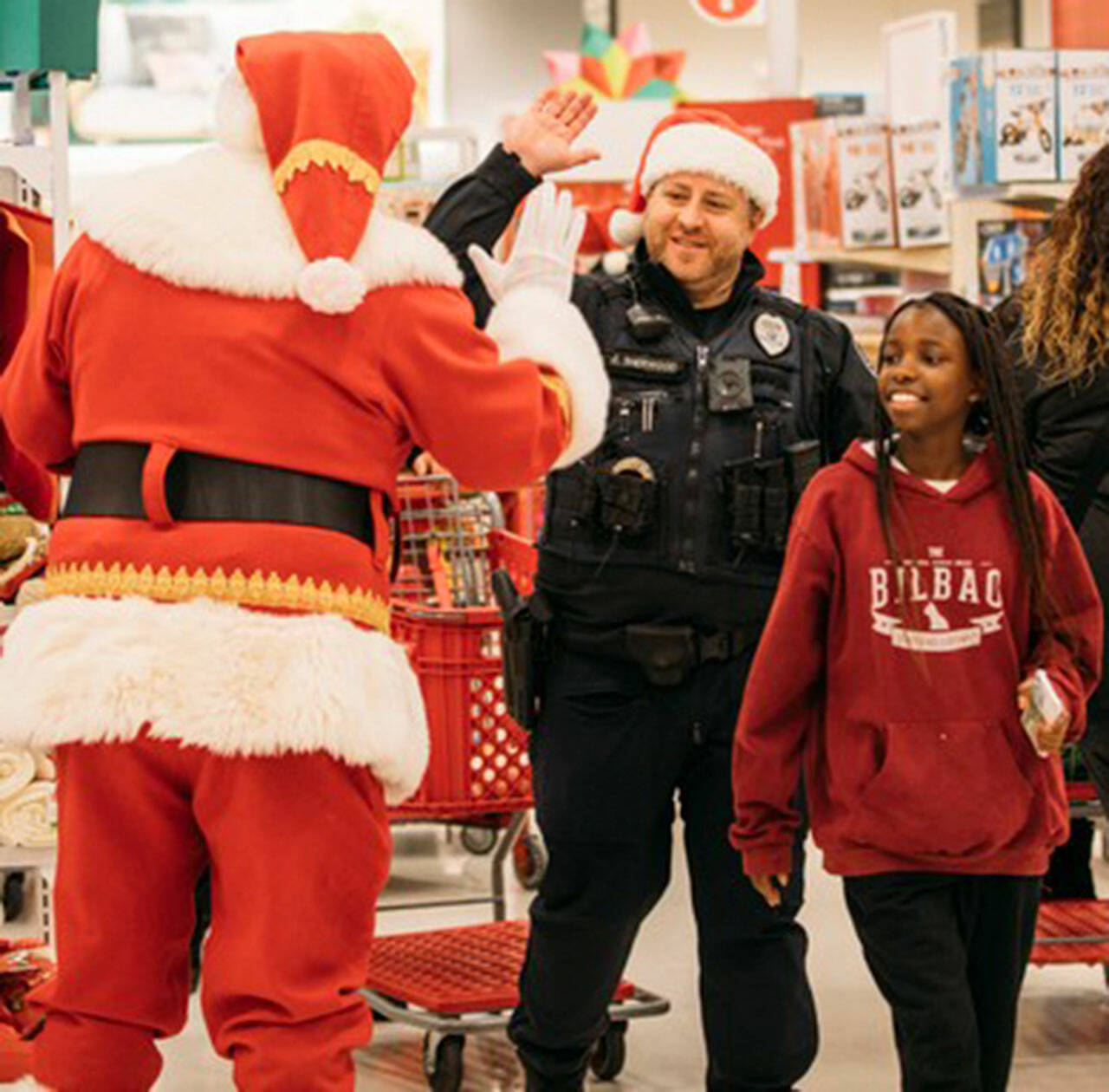 Santa Claus greets Kent Officer Sherwood and a girl Dec. 9 at Target during Shop with a Cop. COURTESY PHOTO, Kent Police