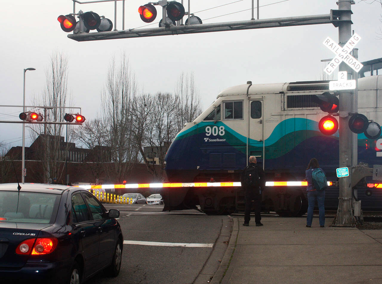 Pedestrians wait for a Sounder commuter train at the Smith Street crossing in Kent. STEVE HUNTER, Kent Reporter