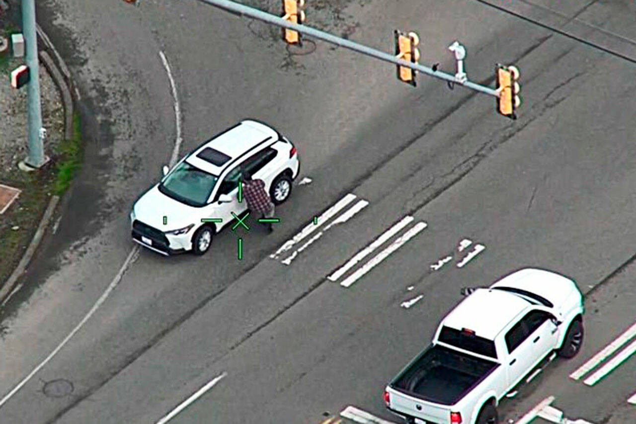 A man approaches a vehicle in an apparent attempt to carjack it Monday, Feb. 13 in Kent near South 277th Street and West Valley Highway. COURTESY PHOTO, King County Sheriff’s Office/Kent Police