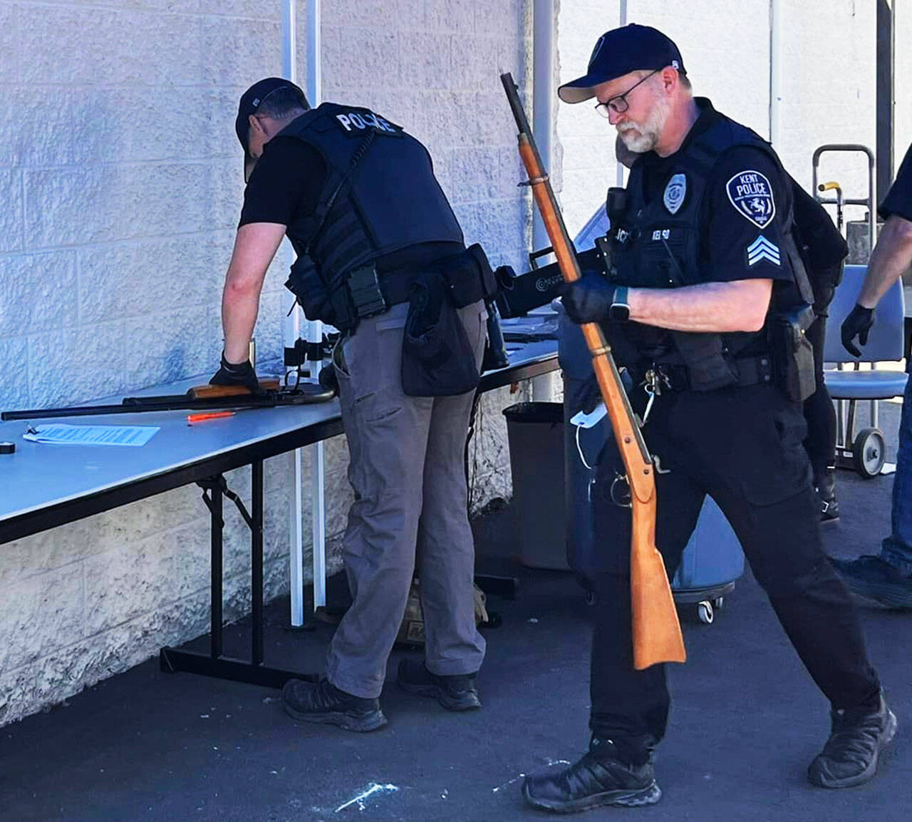 A Kent Police officer carries a gun returned during the June 3 buyback at the Kent Police/Fire Training Center on the East Hill. COURTESY PHOTO, Zandria Michaud, Kent Police