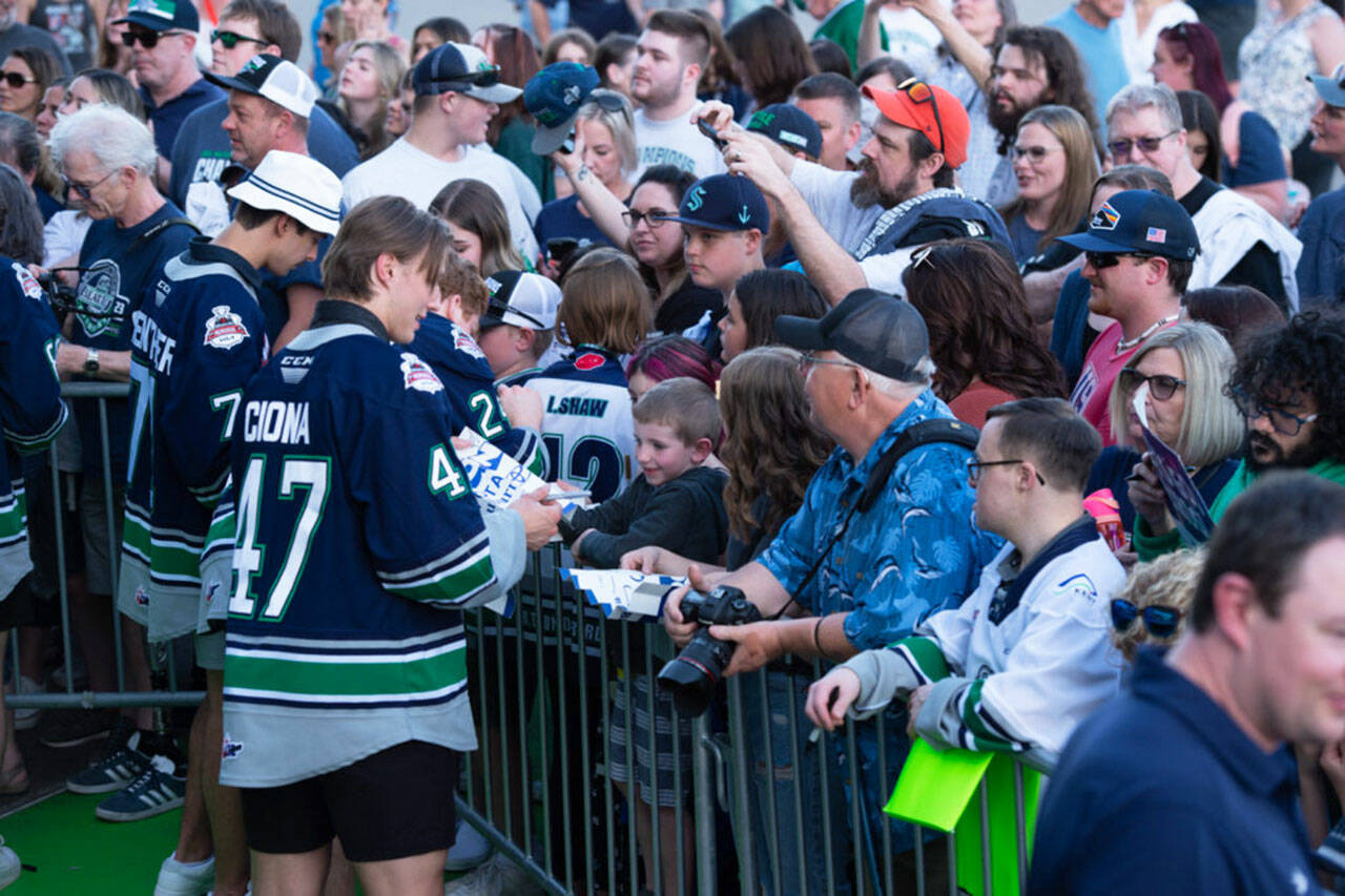 Dylan Guenther, left, and Lucas Ciona sign autographs. COURTESY PHOTO, Brian Liesse, Seattle Thunderbirds