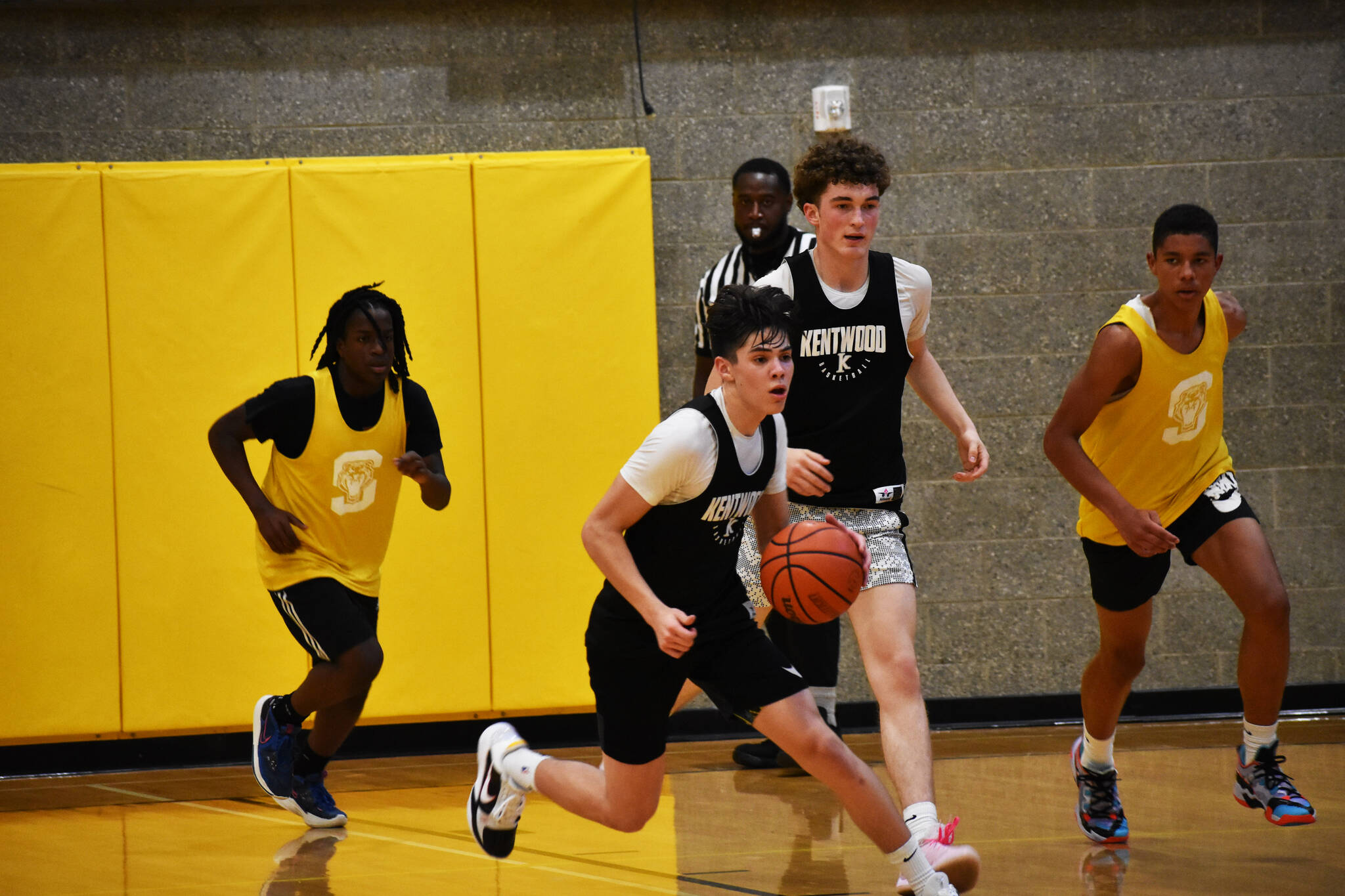 Brandon Tagle makes a dribble move on a fast break for the Kentwood summer league team. BEN RAY, The Reporter