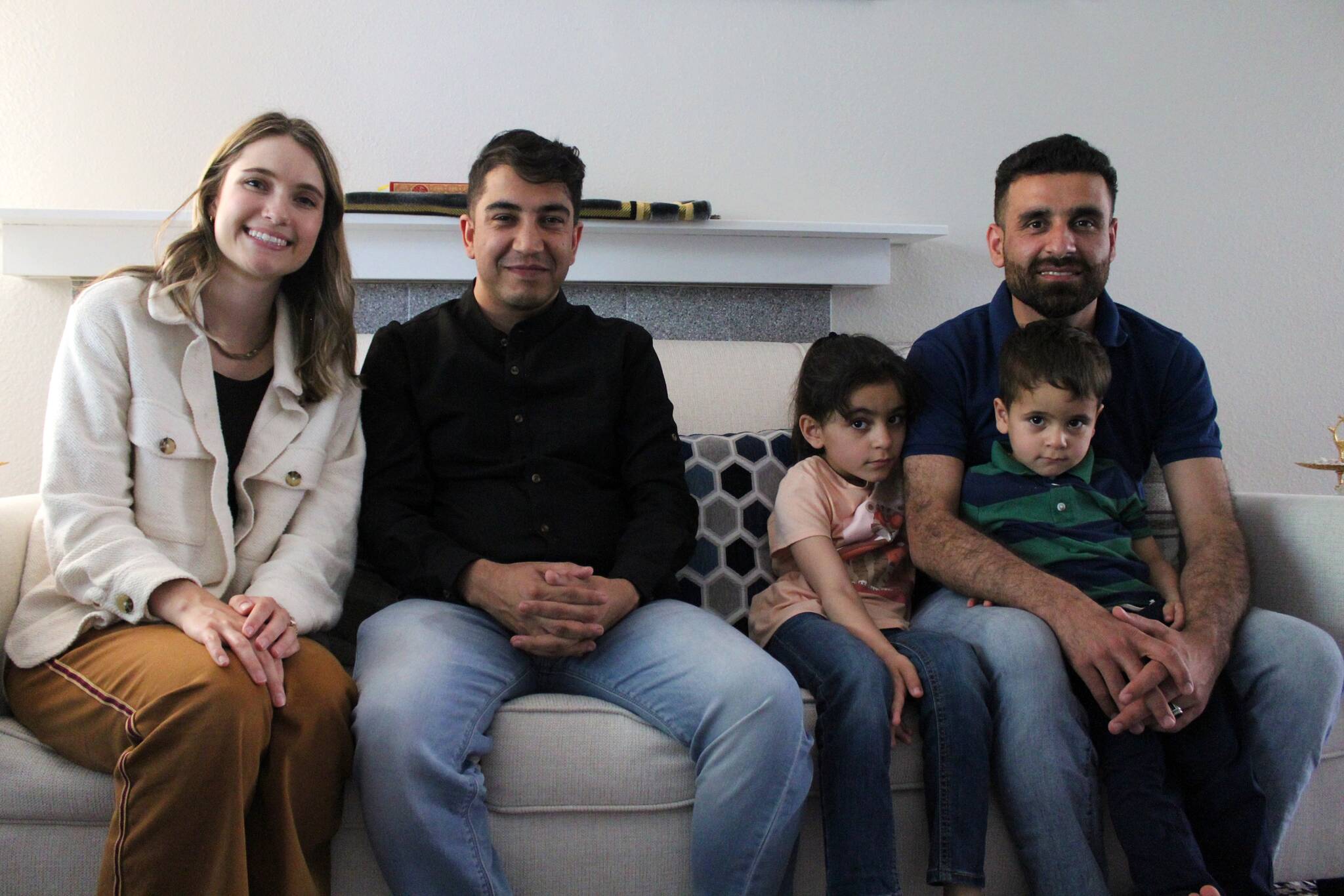 Left to right: Heather Brandt, program manager for refugee and immigrant services at Lutheran Community Services Northwest; Ghulamfarooq Noorzai, case manager for the Stanikzai family, and Hamid Stanikzai, along with two of his children, pose for a picture at his Federal Way area home. (Photo by Alex Bruell / The Mirror)