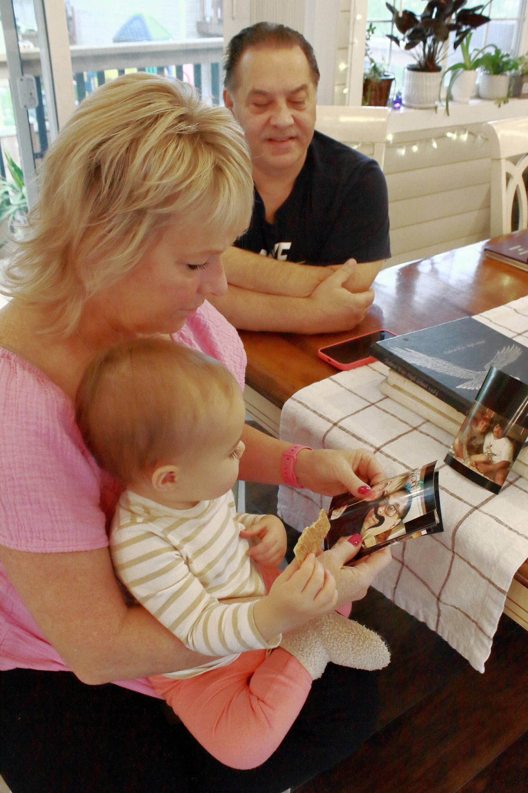 Dale and Denise with their first grandchild looking at family photos and reminiscing. Photo by Keelin Everly-Lang / The Mirror.