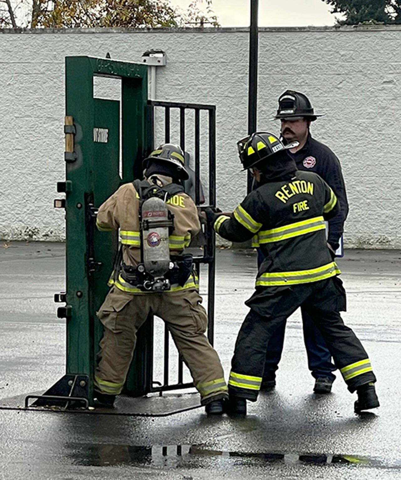 Recruit firefighters are taught how to force entry through a door. COURTESY PHOTO, Puget Sound Fire