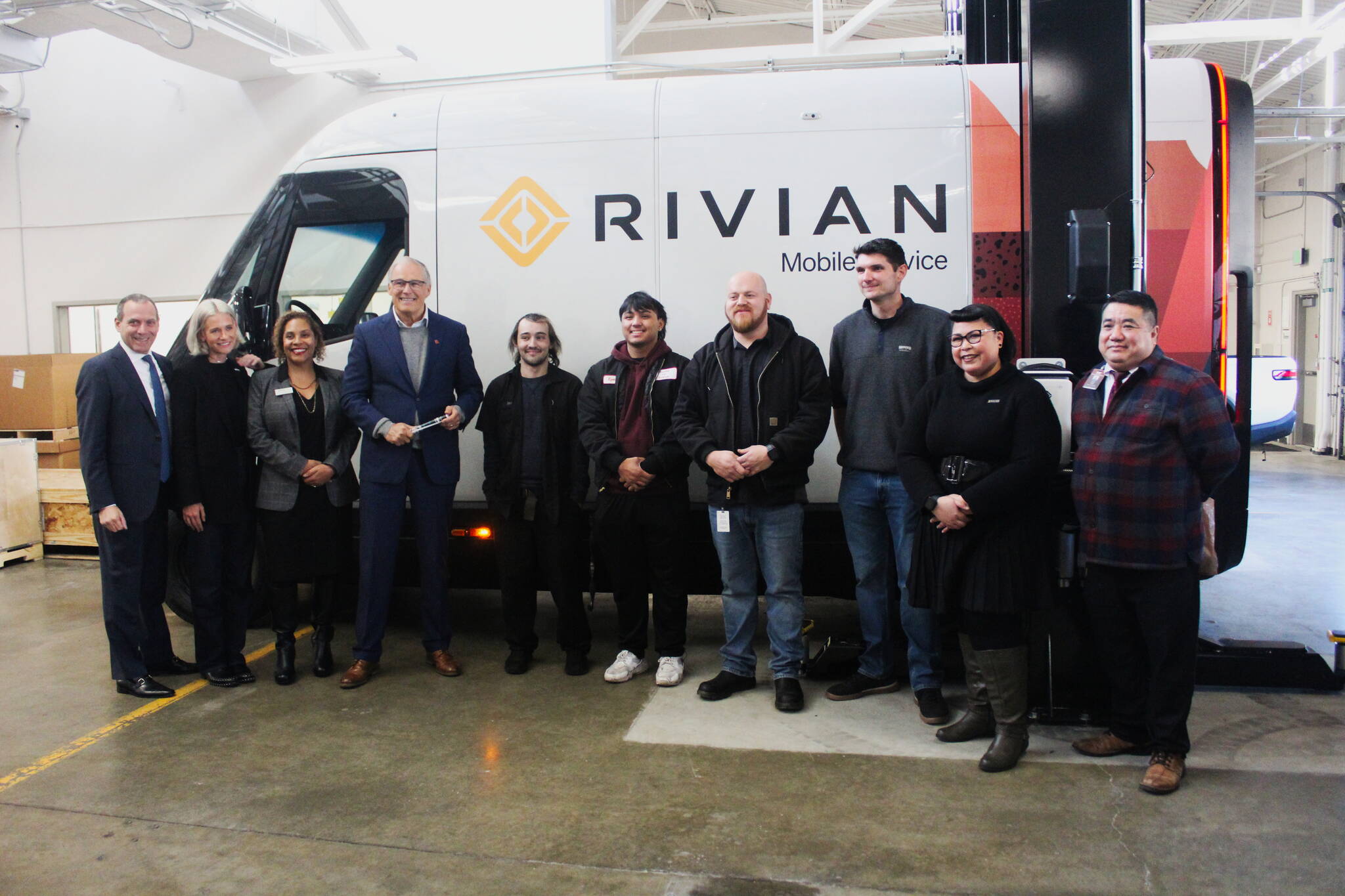 Gov. Jay Inslee, along with Rivian associates, Renton Technical College staff and RTC students in front of a Rivian mobile service vehicle after the governor toured the new program space. Photo by Bailey Jo Josie/Sound Publishing.