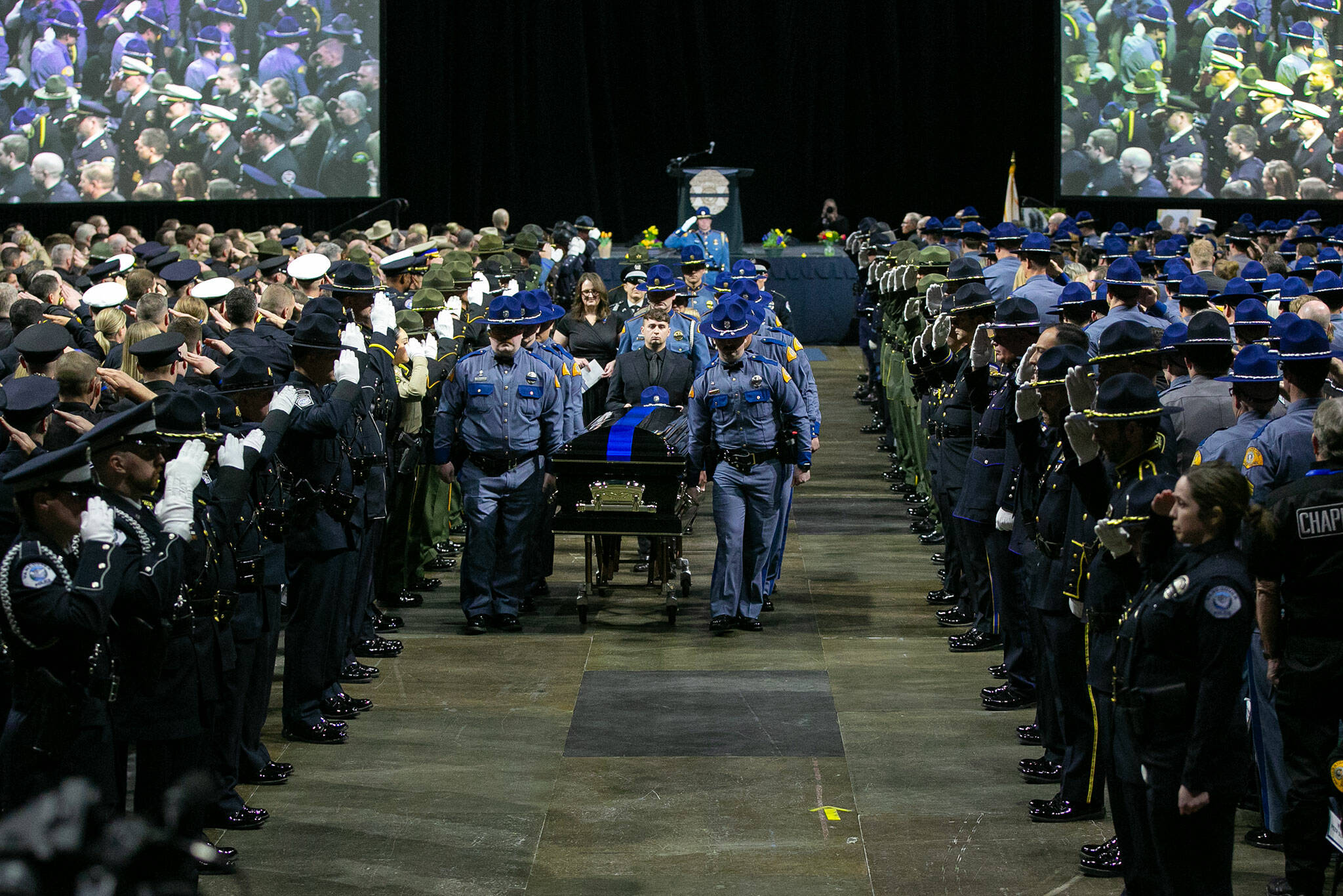 Washington State Trooper Chris Gadd is brought out by fellow troopers following a memorial ceremony on Tuesday, March 12, 2024, at Angel of the Winds Arena in Everett, Washington. (Ryan Berry / The Herald)
