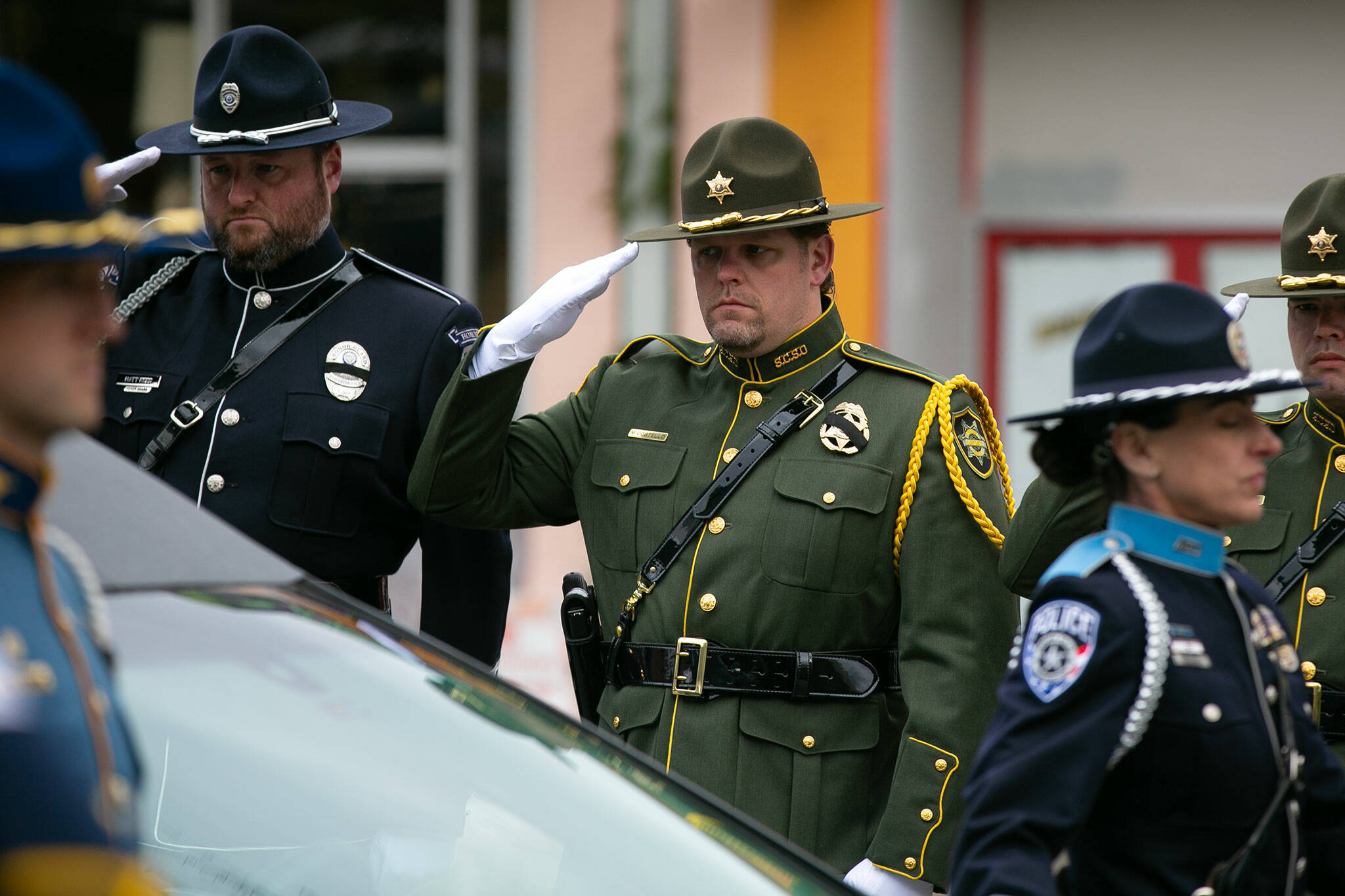 Law enforcement salute Washington State Trooper Chris Gadd during a processional on Tuesday, March 12, 2024, at Angel of the Winds Arena in Everett, Washington. (Ryan Berry / The Herald)