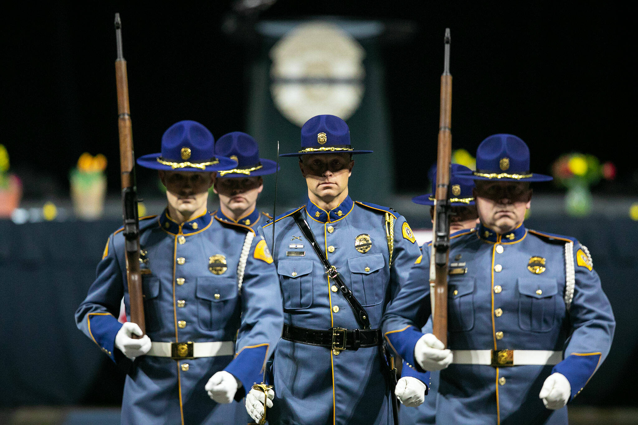 Washington State Troopers perform a ceremony during a memorial for fellow trooper Chris Gadd on Tuesday, March 12, 2024, at Angel of the Winds Arena in Everett, Washington. (Ryan Berry / The Herald)