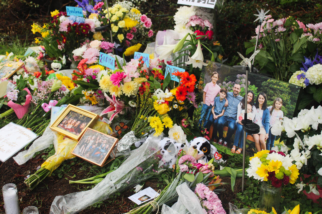 Flowers, framed photos, plush toys and a QR code to the GoFundMe pages of the families grace the memorial site after the March 19 crash. Photo by Bailey Jo Josie/Sound Publishing.