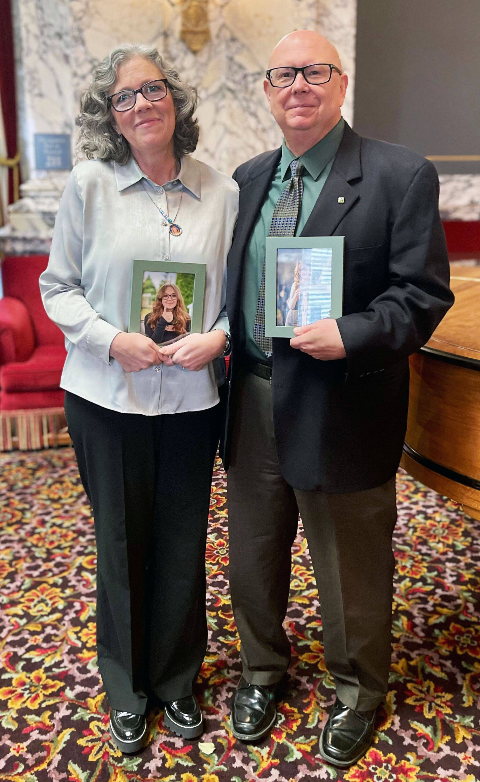 Laura and Todd Goldsmith hold framed portraits of their daughter Madeline Goldsmith inside the Capitol building in Olympia. COURTESY PHOTO, LifeCenter Northwest