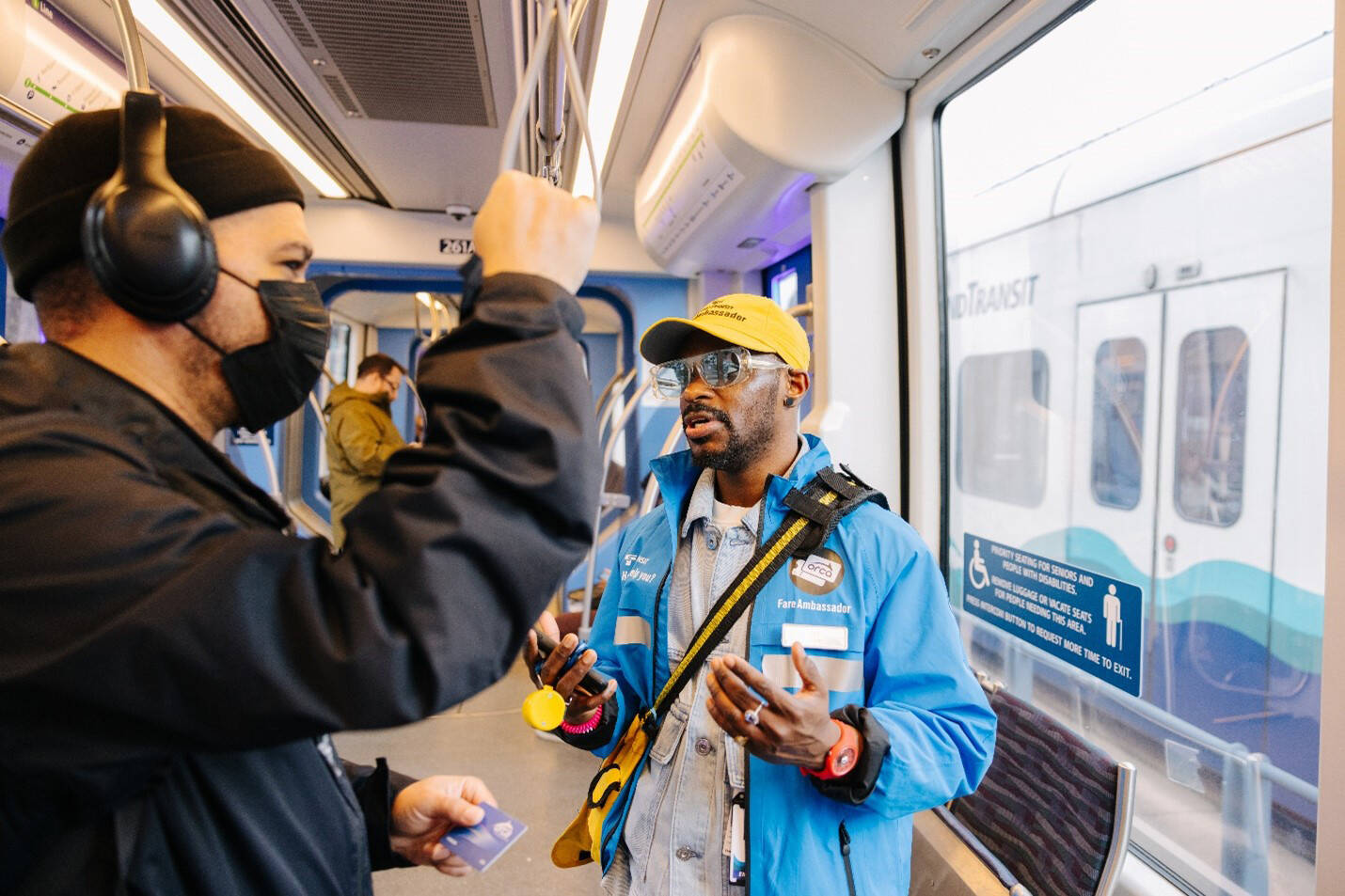 A Sound Transit fare ambassador checks with a light rail rider. COURTESY PHOTO, Sound Transit