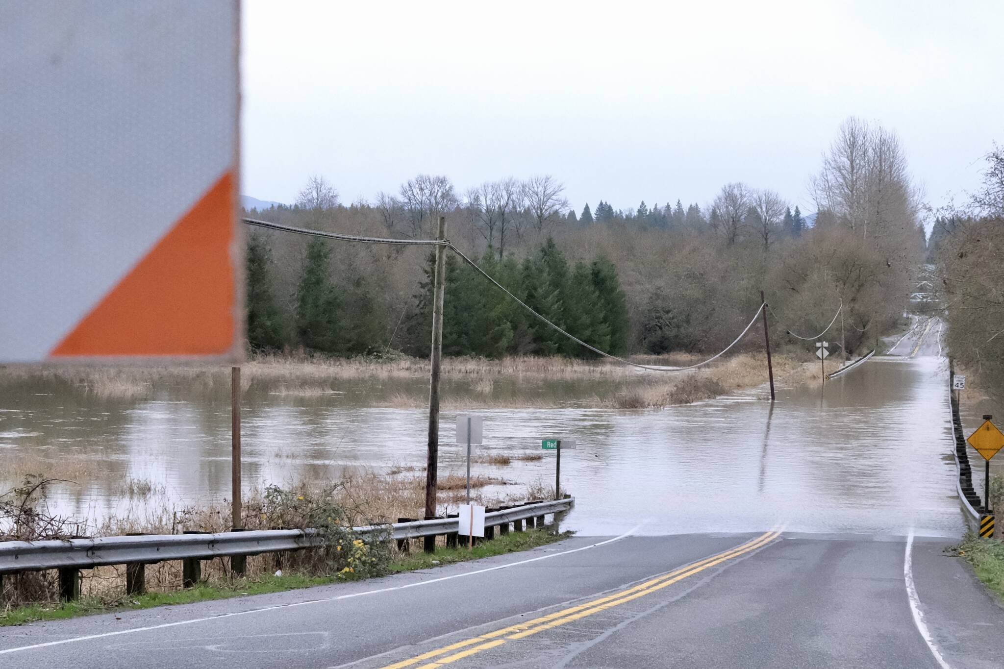 Flood waters flow over NE 124th Street at West Snoqualmie Valley Road NE outside Duvall, Dec. 9, 2025. (Grace Gorenflo/Sound Publishing)
