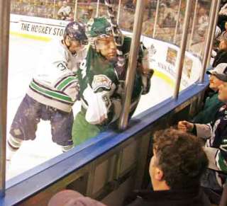 Thunderbirds' Jeremy Boyer (blue and white) hammers Silvertips' Taylor Ellington into the dasher boards as the fight for possession during the T-Birds' opening game at the ShoWare Center. The T-Birds went to win 4-3 against the Silvertips.