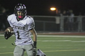 Kentwood's Isaiah Williams darts into the open field against Kent-Meridian on Friday night. Williams scored one touchdown and intercepted two passes in the Conks' division-clinching win.