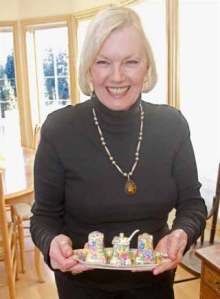 Ros Winslow shows off one of her prized antiques. She has glassware displays in several rooms of her house