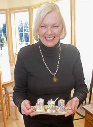 Ros Winslow shows off one of her prized antiques. She has glassware displays in several rooms of her house