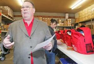American Preparedness President Jeffrey Guite describes what goes into the Kent-based company's emergency kits Jan. 20. A batch of the company's kits are about to go to Haiti through the Red Cross. Behind him Warehouse Supervisor Tonya Duncan builds a set of the kits. The company's warehouse is located in SeaTac near the airport.