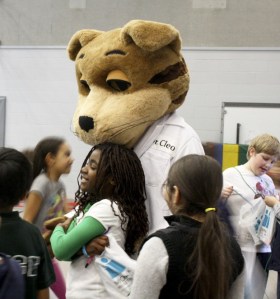 Precious Karbraid gets a hug from mascot Dr. Cleo of Molina Healthcare.