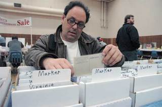 Bellevue resident Stu Jacobson (lower right) looks through vintage postcards at last year’s Greater Seattle Postcard and Papers Collectibles Show. The show returns to Kent this weekend