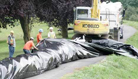 Fardig Development crews place the super sacks last month along the east bank of the Green River that borders the Riverbend Golf Course. The workers